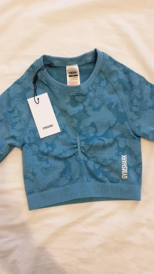 Gymshark topp - Gymshark adapt camo seamless long sleeve crop topp. Aldrig använd och prislappen är kvar.