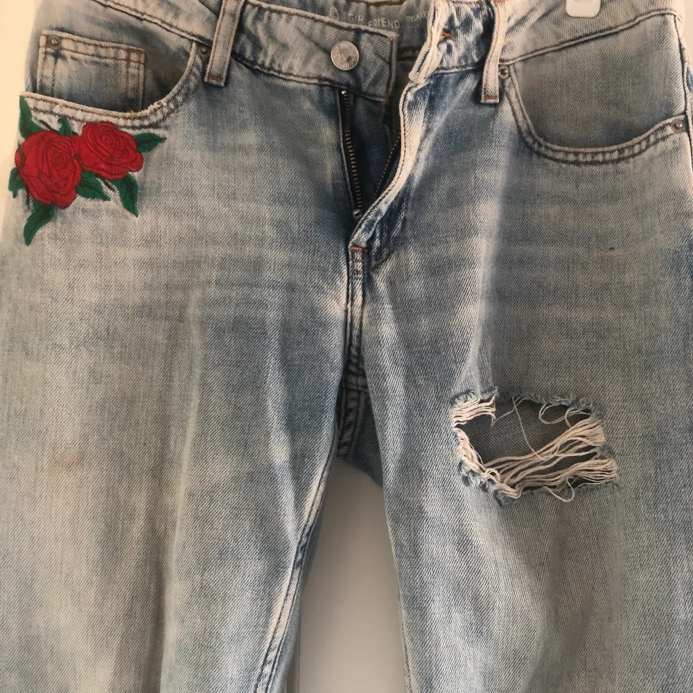 Jeans med dekorativa hål och broderad ros. Storlek: XS (relaxed modell) Märke: Köpt från Cubus. Använd men den är i okej skick. . Jeans & Byxor.