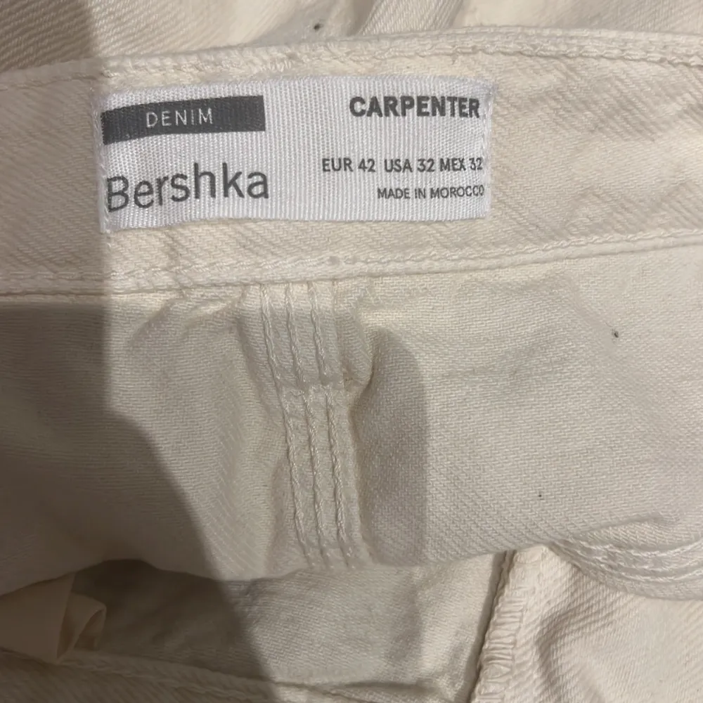 Oanvända snickarbyxor från Bershka i storlek 42. Krämvita/ljusbeiga.. Jeans & Byxor.