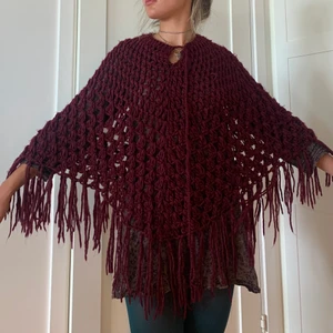 Vinröd stickad poncho  - Vinröd poncho köpt second hand. Gissar hemstickad. Varm o mysig! Inga defekter🎀