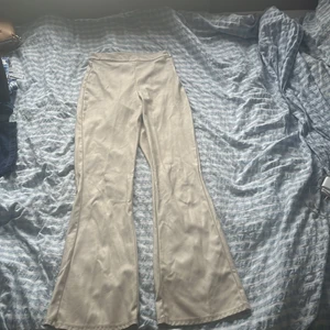  Beiga bootcut byxor  - Innerbenslängden 78cm  midjan 62cm  Stretch material, sköna att ha på sig men inte riktigt min stil längre.