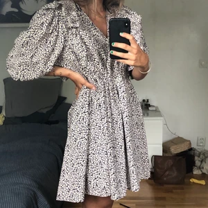 Klänning från h&m - Fin och riktigt skön klänning från h&m med puffärm och volanger på överdelen. Det syns ej så tydligt på bilden men tyget har små vita blommor