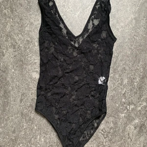 Svart body storlek xs  - En blommig svart spetsbody i storlek XS. Använd men i bra skick. Frakt tillkommer. 