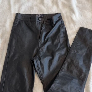 Läderbyxor - 20%polyamide/polyester?  3%elastisc 77%viscose/a. Bra skick, lite "tygfel" men inget man ser direkt eller tänker på. Sitter jätteskönt och framhäver kroppsformen på ett bra sätt. Lite korta på mig som 172cm.