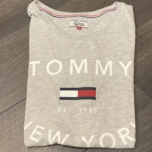 T-shirt Tommy Hilfiger  - Säljer en ljusgrå T-shirt från Tommy Hilfiger i storlek S, använd ett fåtal gånger men är i mycket fint skick. Kan tänkas mötas upp i Växjö annars står köparen för frakten☺️