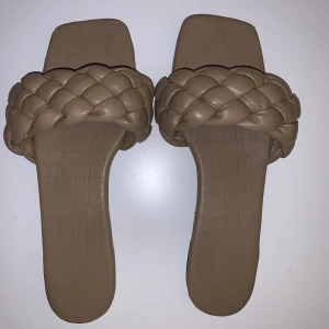 Beigbruna Slippers, Storlek 38 - Supersköna beigbruna tofflor i fakeskinn. Storlek 38. Använda någon enstaka sommarmånad. 🏖️