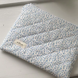 Necessär  - En platt lite mindre necessär som är perfekt att ha i väskan! Färgen är vit på insidan och hr ett blått mönster på utsidan. Ej använd. 