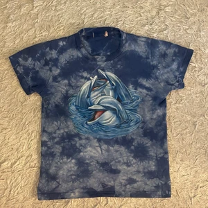 00-tals delfin tröja🐬 - Så fin babytee med delfin! Perfekt till sommaren 💕💕🐬 Står strl 140 på lappen men passar xs-m beroende på hur tight den ska sitta! Köpt här på plick 