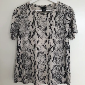 T-shirt från Lindex - Snygg ormmönstrad t-shirt från Lindex i storlek M. Nyskick, nypris ca 300kr.