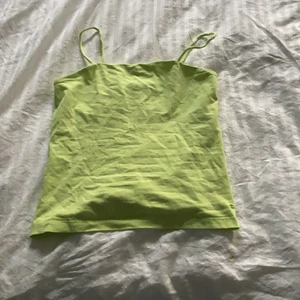 Grönt linne - Från Kappahl tror jag! Ca 1 år gammalt, ytterst lite använt. Det är grönt/ neon grönt. Den andra bilden på insidan! Storlek 158/164 eller XS! Frakten som står gills INTE! Utan diskuteras privat!