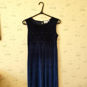 Drömklänning   - Mjuk klänning ner till fötterna. Ej nattlinne. Vet ej om det är till bal. Medeltid. Köpt på öströ fårfarm. Pärlor lossnat. En svag fläck. För mörk. Storlek 158. Men är vuxen. Passar 38.  