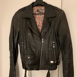 Jofama by Kenza skinnjacka strl 38 - Jofama by Kenza skinnjacka 3, strl 38. Välanvänd men skinnet är i fint skick och nu mjukt och väldigt bekvämt, behandlat flera gånger för hållbarhet. Däremot är kedjornas hake tappat silverfärg och är rosa, syns detaljer på andra och tredje bilden. Detta är inget som stör mycket eller speciellt synligt, men jag drar ner priset för det. Nypris ca 3000kr