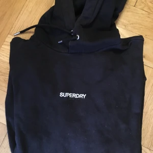 Superdry hoodie - Bra skick, snygg färg. Färgen passar till i princip allting. Skriv privat vid behov av bild på hoodien på kroppen.  Inköpspris: 550kr