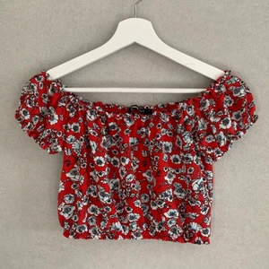 Blommig topp - En väldigt fin och röd blommig topp❤️ den e croppad och har sidor armar dvs inga band som gör att ens axlar visas väldigt fint. För mer frågor om hur den sitter på mm så kontakta mig❤️