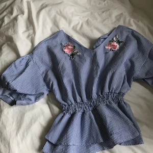 Blus/topp - Randig topp med rosor på framsidan. Lite volang. bra skick