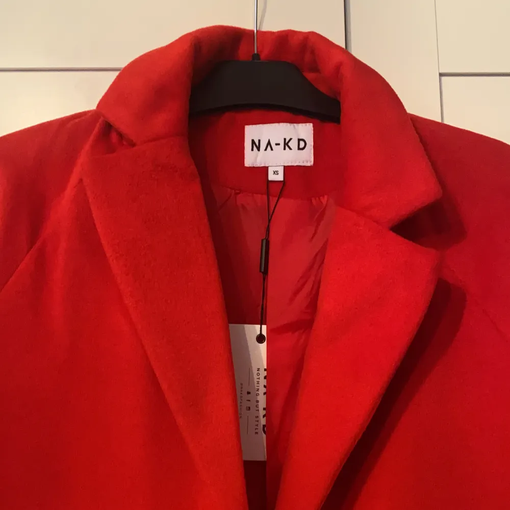 Röd kappa från NAKD. Aldrig använd så den är i nyskick . Jackor.