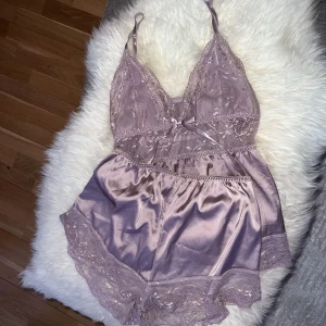 Satin pyjamas set  - Superfint dusty lila satinpyjamas med spets detaljer. Materialet är mjukt och även stretchigt, reglerbara axelband. Strl M (passar även S)  Nyskick