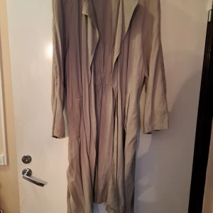 Mjuk trenchcoat  - Olivgrön ttenchkoat i oanvänt skick. Passar perfekt till våren. Känns lite mindre i storleken.  Kan behöva strykas då den varit ihopknöglad i fägarderoben. 