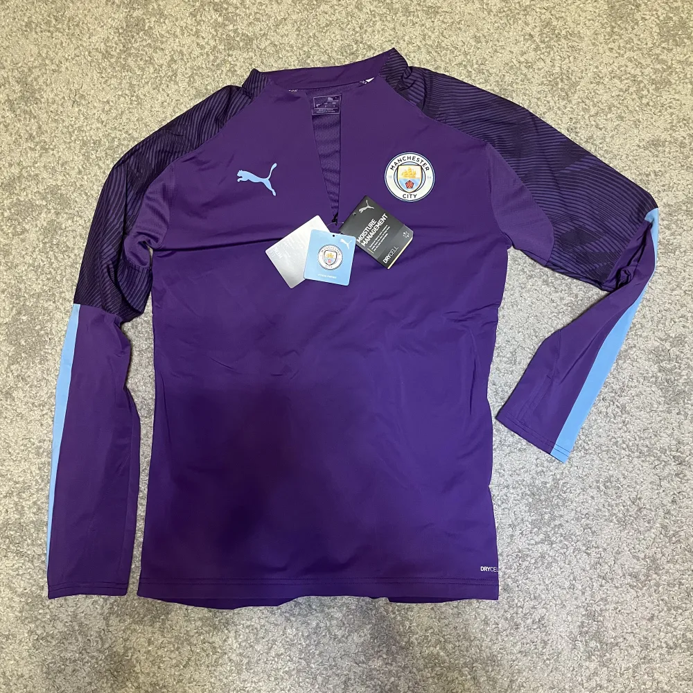 En Manchester City träningströja med half zip från 2019-2020 säsongen med tags kvar. Helt oanvänd och därmed är den i 10/10 skick. Den är äkta och pris kan diskuteras.. Hoodies.