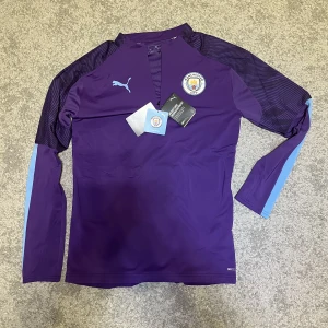 Manchester City träningströja - En Manchester City träningströja med half zip från 2019-2020 säsongen med tags kvar. Helt oanvänd och därmed är den i 10/10 skick. Den är äkta och pris kan diskuteras.