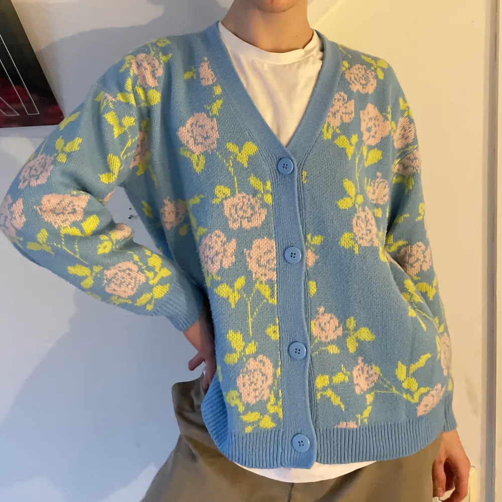 Ljusblå oversized stickad kofta med grönt och rosa blommigt mönster från Urban Outfitters 🌸 . Tröjor & Koftor.