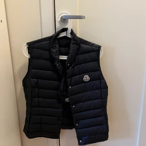 Moncler väst - Mörkblå monclerväst i strl 2. Västen är i perfekt skick och bara använd några gånger. Den är inköpt på Nathalie Schuterman och kvitto finns. 