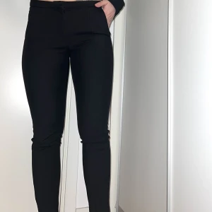 Kostymbyxor - Snygga tighta kostymbyxor, perfekt till någon snygg top! Bra skick! Går att ”öppna upp” längst ned med diskret liten dragkedja. 