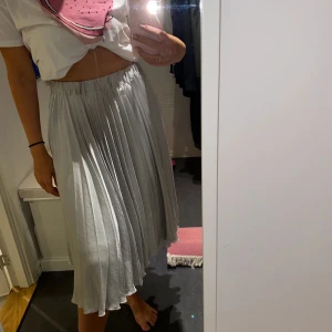Kjol i glansigt material - Kjol i glansigt material från Gina Tricot, strl. XS. Fint fall. Bra skick.