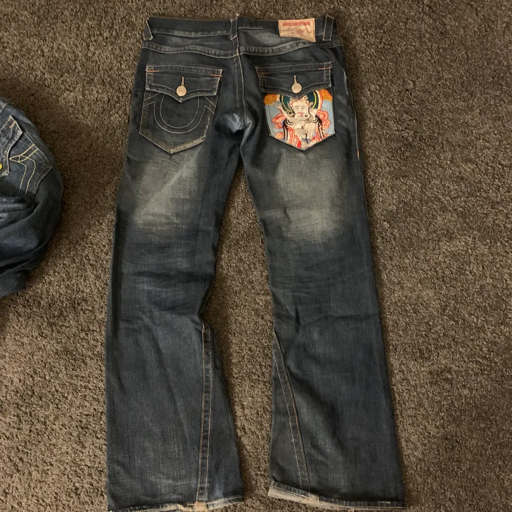 Sjukt snygga true religion jeans med en super cool broderiet på ena bakfickan. Pappas gamla från 90-talet så definitivt unika. 💗 kolla min profil för fler jeans. Innerbenslängd: 77 cm, midjemått tvärs över: 44 cm. . Jeans & Byxor.