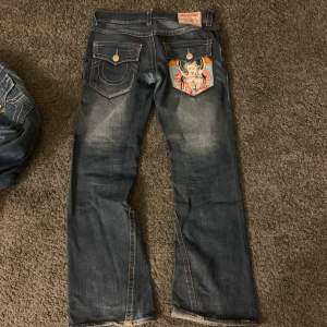 Sjukt snygga true religion jeans med en super cool broderiet på ena bakfickan. Pappas gamla från 90-talet så definitivt unika. 💗 kolla min profil för fler jeans. Innerbenslängd: 77 cm, midjemått tvärs över: 44 cm. 
