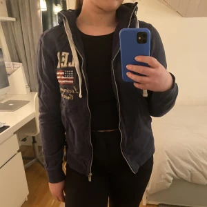 Lexington kofta - Lexington kofta med luva, riktigt bra skick. Denna modell går inte längre att köpa ny. En mörkblå färg med smycke tryck. True to Size!  Trakt ingår ej. 