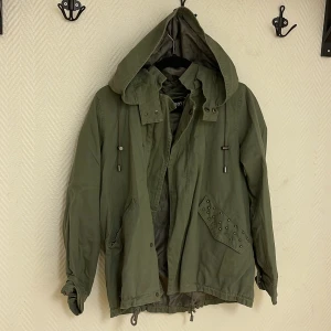 Gröna jacka med super fina detaljer  - Jacka i grön färg med fina detaljer på rygg och fickor. Knappt använd och super fin.   Köparen står för frakten. Jag visar bild när jag skickar paketet. Vid fler intressen av kläderna kan bud läggas