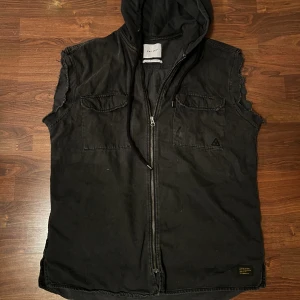 Snygg väst - Snygg väst som jag klippt av armarna på själv.  Storlek M/L Gråsvart