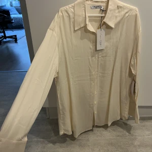 Lojsan Wallin x NA-KD skjorta - Ny skjorta i ett mjukt skinande material med en oversized passform. Skjortan är från Lojsan Wallins kollektion med NA-KD som är slutsåld på hemsidan. Skjortan finns bara kvar i grön(bifogar bilder) på hemsidan. 68% viskos, 32% polyester