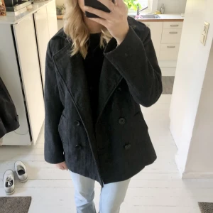 Kort kappa - En kort kappa i grå. Jätte bra skick och har fina detaljer!
