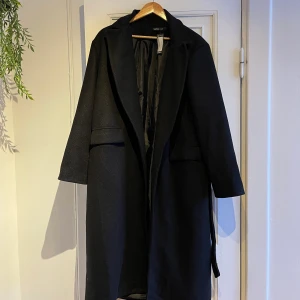 Svart kappa  - Helt oanvänd kappa från Boohoo☃️☃️ Köptes för 1 vecka sedan, lappen finns kvar. Kappan är lång och är i storlek 44 men är som en oversize kappa i storlek M. Jag är 174cm lång och på mig sitter den perfekt💫