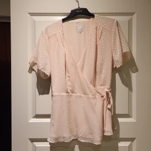 Omlottblus - Figursmickrande blus, omlottmodell. Ljusrosa. Aldrig använd. 