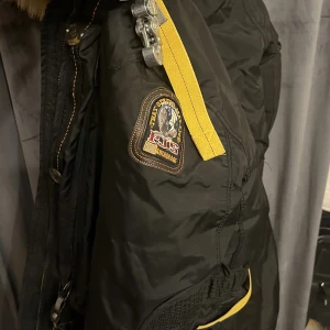 Parajumper jacka 1500 - Jätte fin jacka bekväm o skön att ha till vintern, väldigt tjock päls och går att ta av. De är inget fel på jackan blixt låset har gått sönder men går lätt att fixa. Köparen står för frakten.