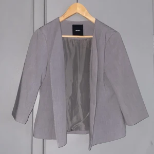 Kavaj - Grå kavaj med kortare ärmar i Stl 38