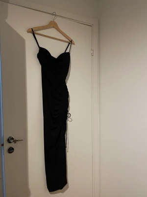 Svart tajt klänning  - En svart tajt klänning från zara i storlek xs. Stretchigt material, sitter fint på kroppen. Slits vid benet som går att reglera. Använt 1 gång, fint skick. Inga fläckar eller annat fel.