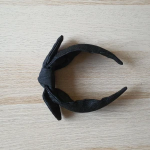 Hårband - Svart glittrigt hårband med rosett på. Knappt använd, nyskick. 