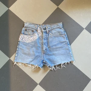 Levis Jeansshorts  - Säljer ett par levisshorts i fint skick. Midjemåttet är ca 66 cm och passar någon med storleken xxs/xs. Jag kan sprätta bort spetsen om det skulle vara så att den inte passar. Skriv till mig privat för fler frågor❤️ Först till kvart!