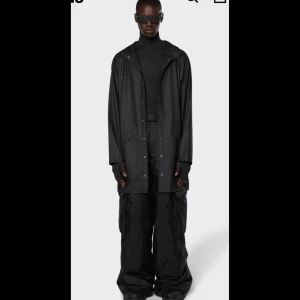 Regnjacka  - Jacket är en tidlös unisexregnjacka som kombinerar mångsidig funktionalitet med en minimal silhuett. Plagget har dubbelförseglade diagonala fickflikar, justerbara manschetter och fishtailfåll. Looken kompletteras av tryckknappsknäppning, öljetter i armhål