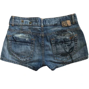 Lowaist jeansshorts  - Ett par lowwaist jeansshorts med en dödskalle på ena fickan🧌 Sitter som en s! Möts upp i gbg annars står köparen för frakt🫶