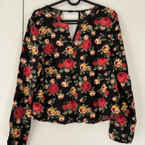 Blus - Blommig blus. Fin detalj vid hals och nacke. Kan skickas