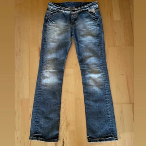 Lågmidjade replayjeans - Lågmidjade replay jeans med rosa/lila detaljer på bakfickorna. Köpta secondhand men tyvärr lite för stora för mig så därför säljer jag dem. Waist 27 och length 32