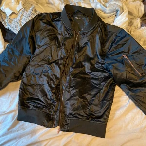 Bomberjacka - En svart bomberjacka i stl S (lite oversize modell) med koppar/roseguld på dragkedjorna. En ficka på varje sida +en liten ficka på vänstra armen 