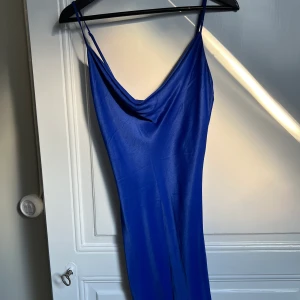 Blå satinklänning - Klänningen är använd en gång och är i fint skick. Den är i storlek small och kommer från Bershka. Jag säljer den för 100kr + frakt. 