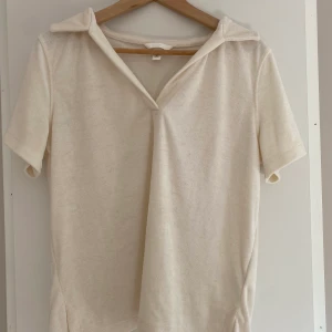 Hm tröja i frotté  - Säljer denna super fina creme vita/ beiga t-shirt från H&M i frotté, den är oanvänd och i storlek M men ganska så liten ❤️den är endast provad, skriv gärna om ni har flera frågor 💓 tryck inte på köp nu 🤩