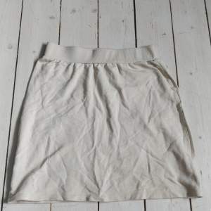 Super snygg mini kjol i beige från nelly i stretchigt material.